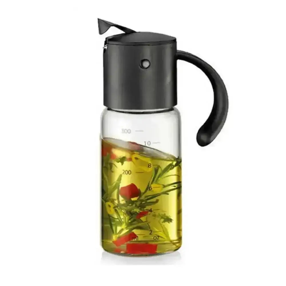 Glass vinegar and oil dispenser with black lid and handle, filled with oil and herbs on a white background