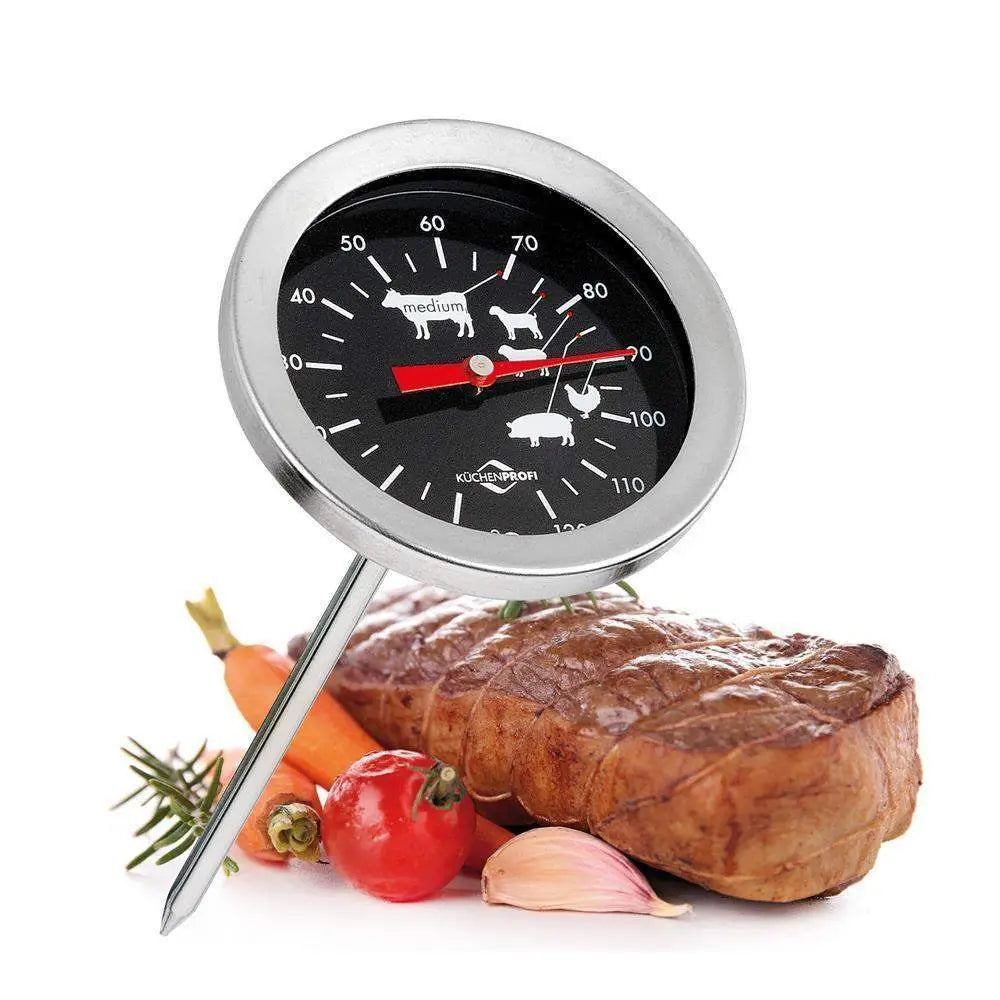 Thermometer for measuring food temperature with a steak, carrots, and garlic on a white background