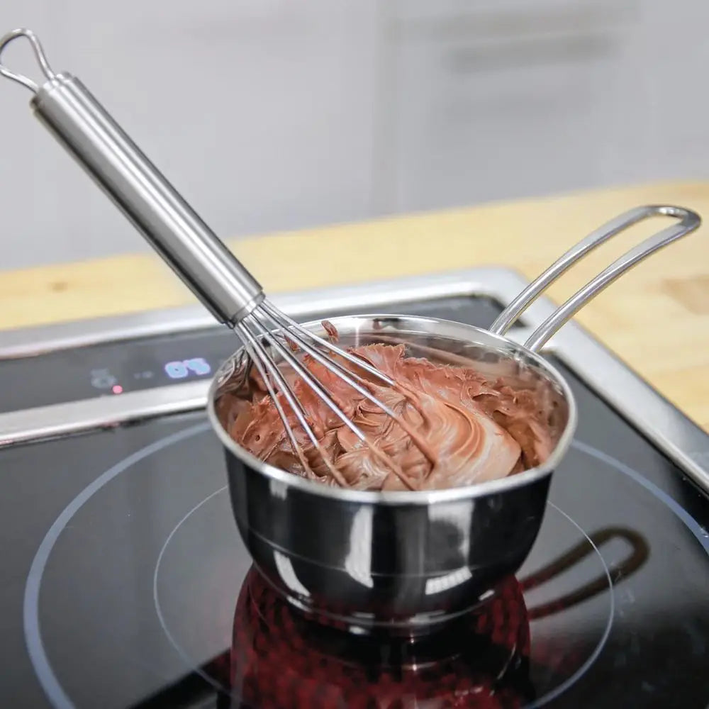 Kitchenprofi stainless steel butter melting pan 250ml with polished whisk stirring melted chocolate in saucepan