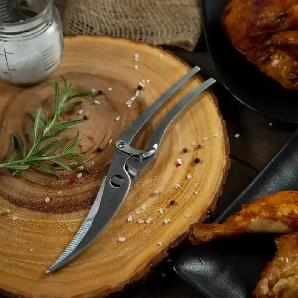 Butterfly knife on a wooden cutting board with roasted chicken and spices