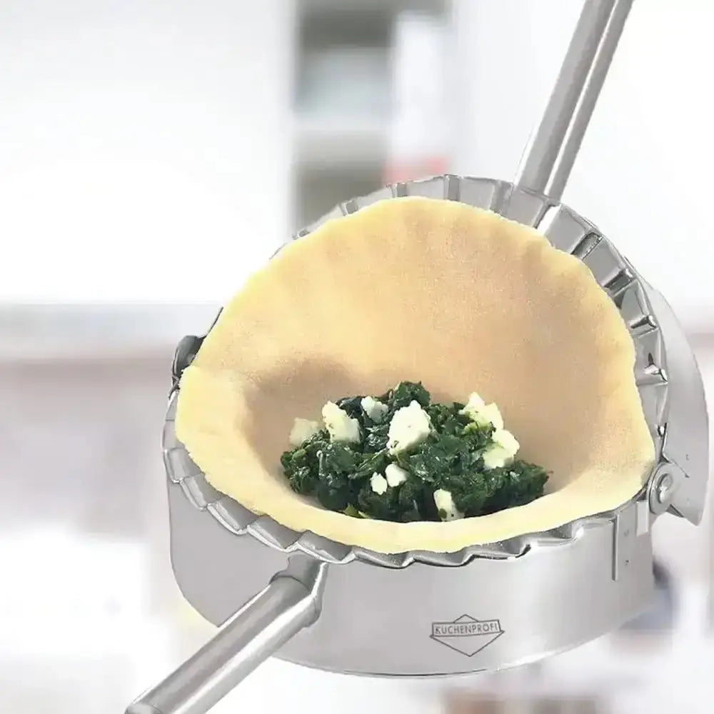 Ravioli press with spinach and cheese filling on a white background