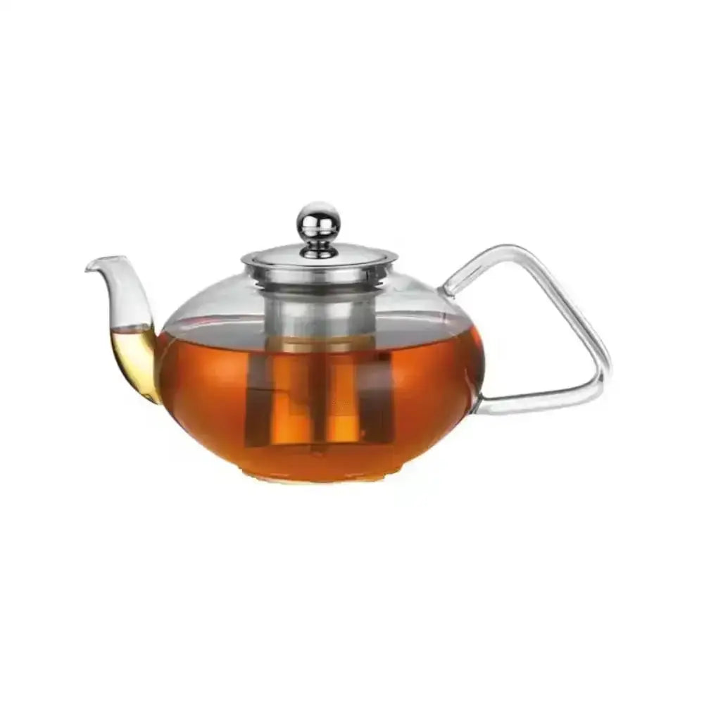 Clear glass teapot with metal lid and handle filled with tea on a white background