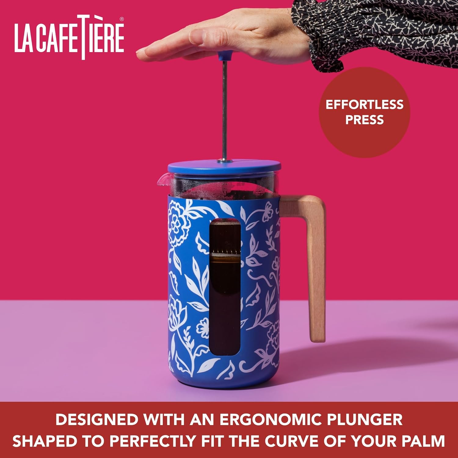 Blue floral-patterned French press with ergonomic plunger against a pink background, featuring La Cafétière branding.