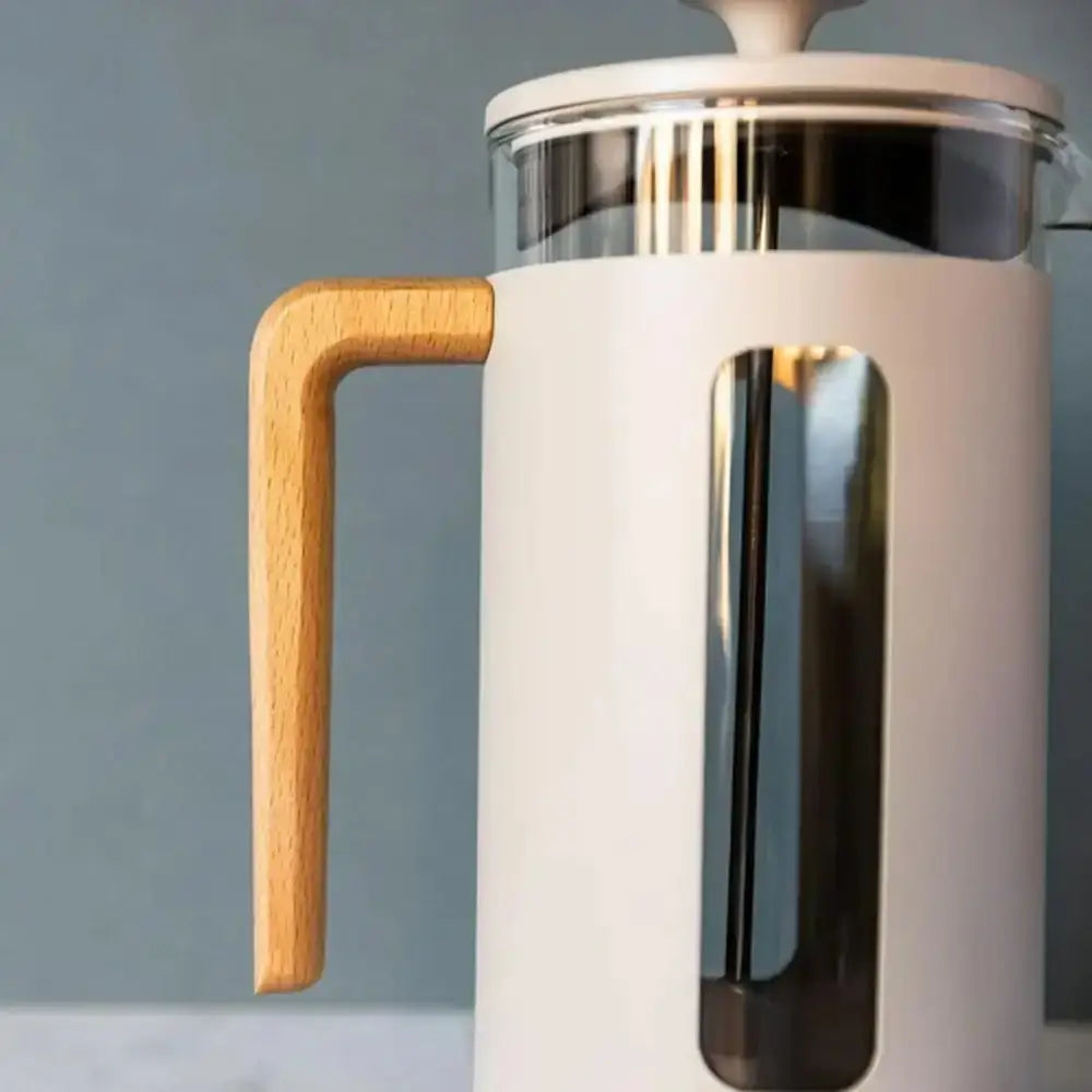 White French press coffee maker with a wooden handle on a gray background