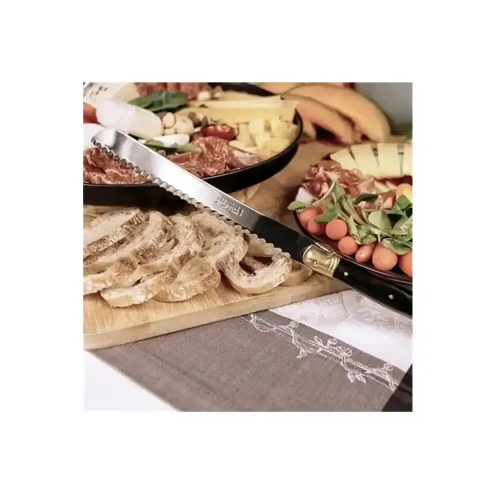 Wooden charcuterie board with bread, meats, and cheeses on a table.