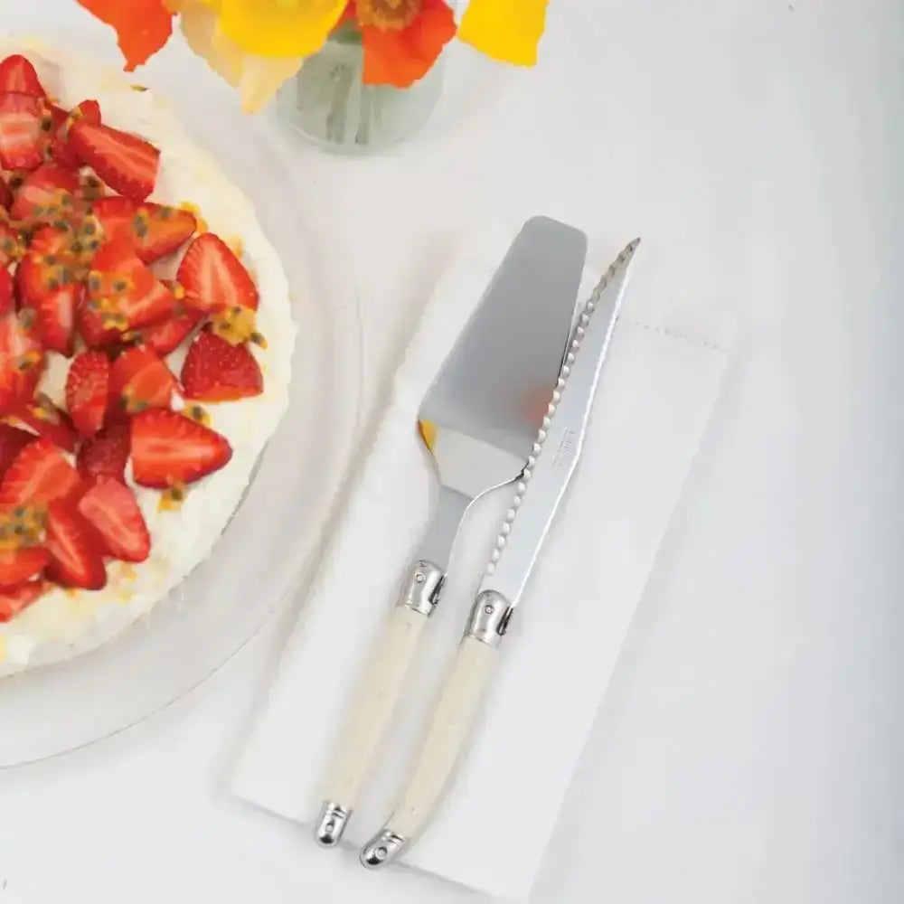Strawberry cake with a decorative knife and fork on a white surface