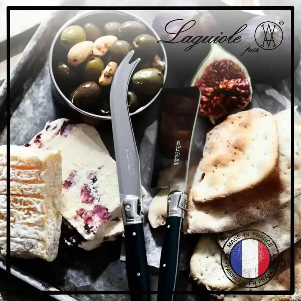 Two Laguiole knives on a plate with olives, figs, and bread, featuring the Laguiole brand logo.