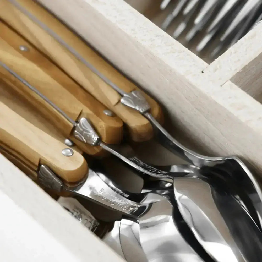 Set of spoons with wooden handles in a wooden crate