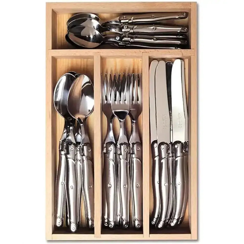 Set of silver cutlery in a wooden drawer organizer on a white background
