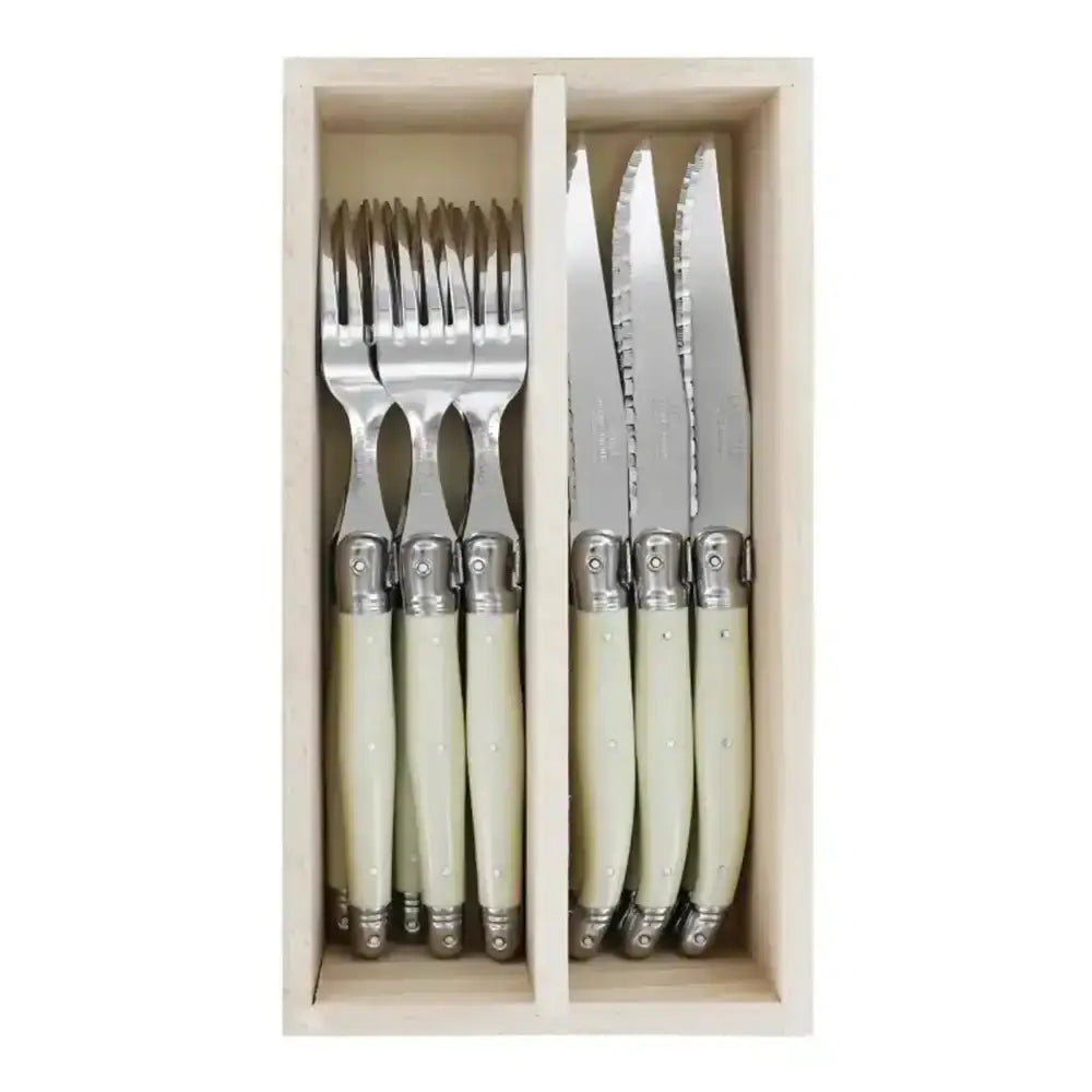 Set of cutlery with cream handles in a wooden box on a white background