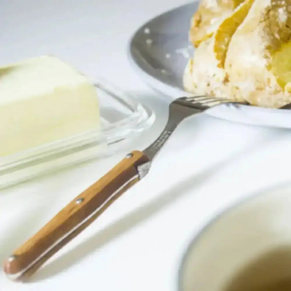 Butter dish with wooden handle and knife on a white surface