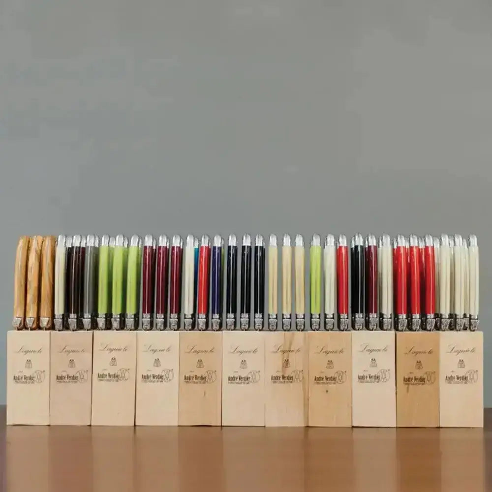 Row of colorful knives with wooden accents on a gray background
