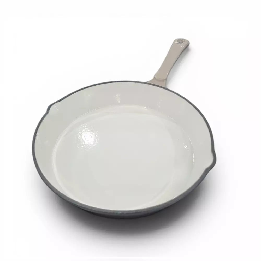 Beige enamel cast iron frying pan with a beige handle on a white background