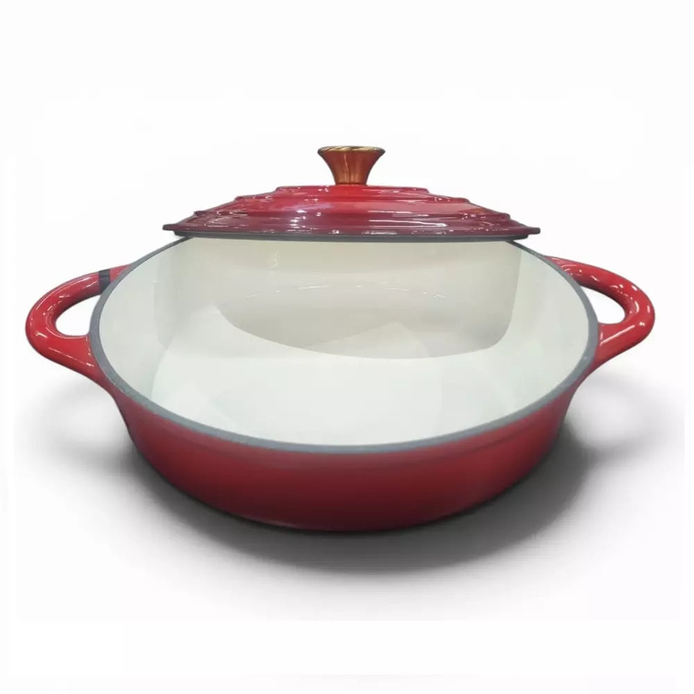 Red enameled cast iron casserole dish with a lid on a white background