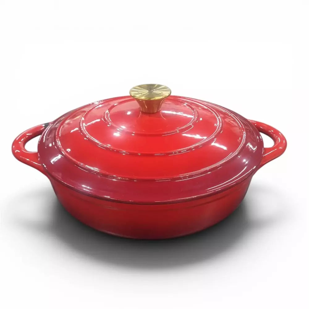 Red cast iron shallow pot on a white background