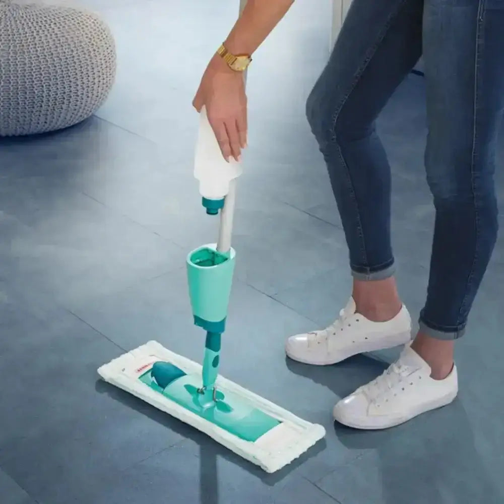 Person using a green and white cleaning device on a floor