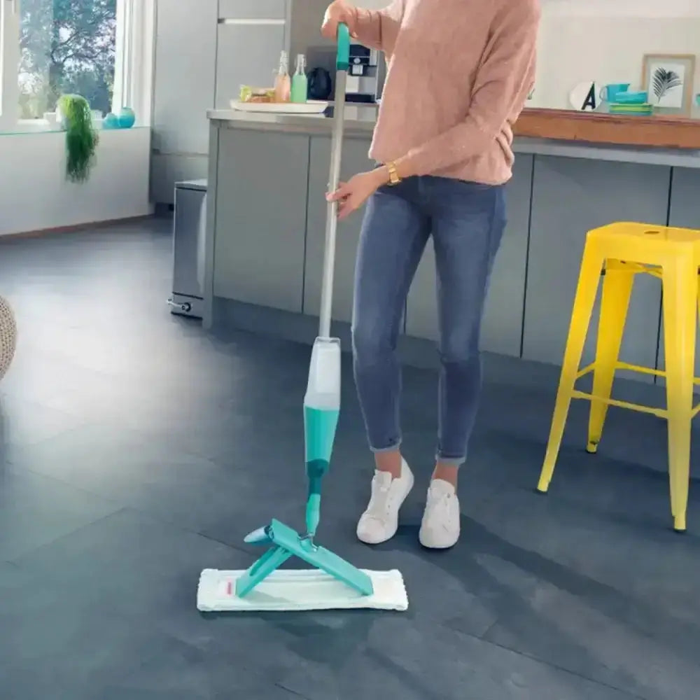 Person using a spray mop on a kitchen floor
