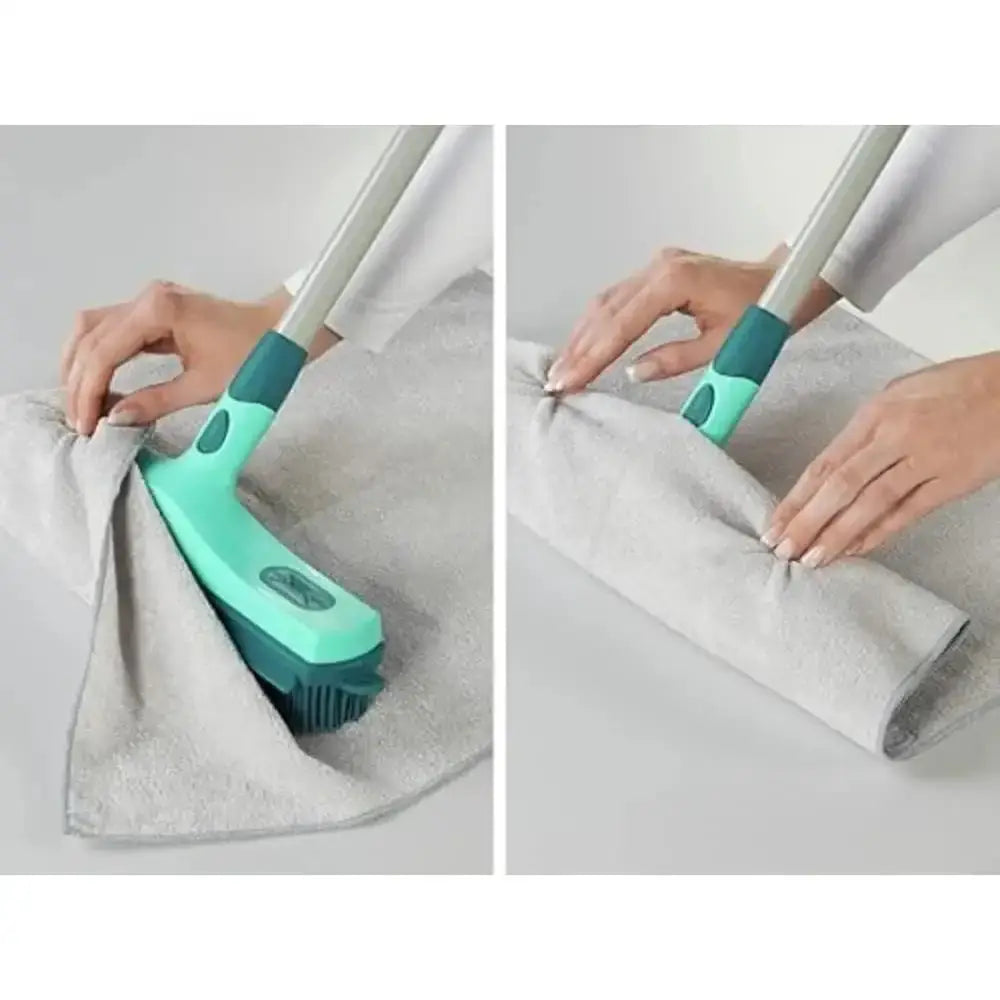 Green cleaning brush with a gray towel on a light gray background