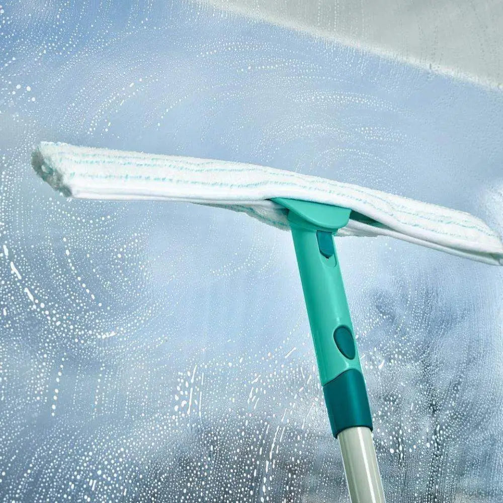 Window cleaning tool with a white cloth on a glass surface