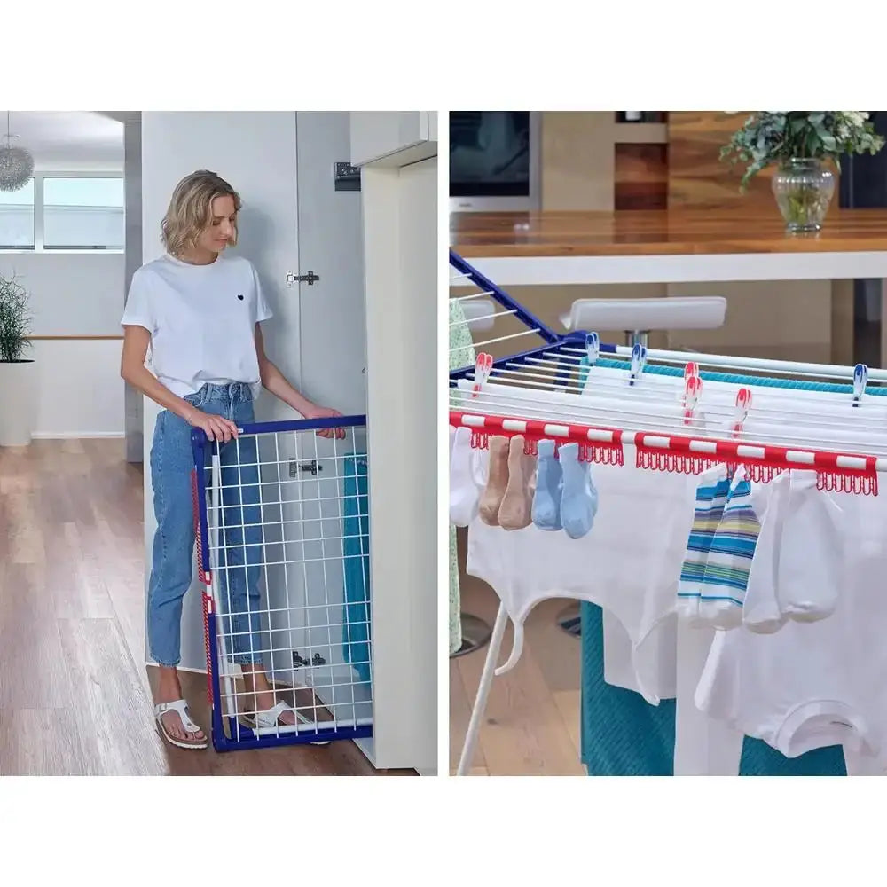 Woman using a baby gate in a room with a table and baby clothes on a rack.