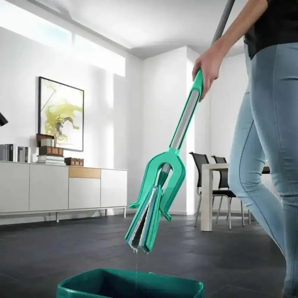Person using a green cleaning tool in a modern living room.