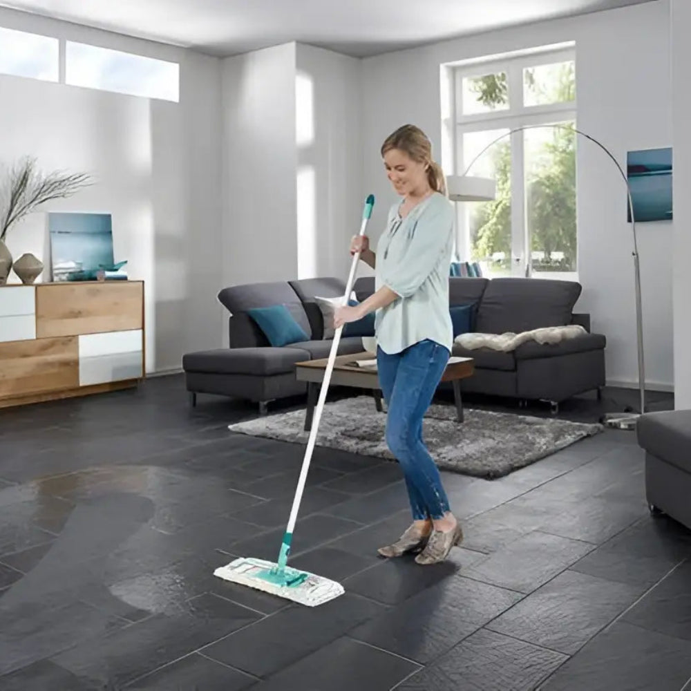 Woman cleaning a modern living room with a mop.