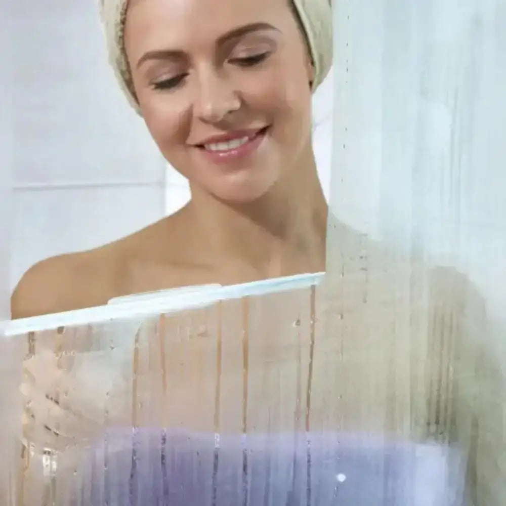 Woman with a towel wrapped around her head in front of a mirror with a white squeegee