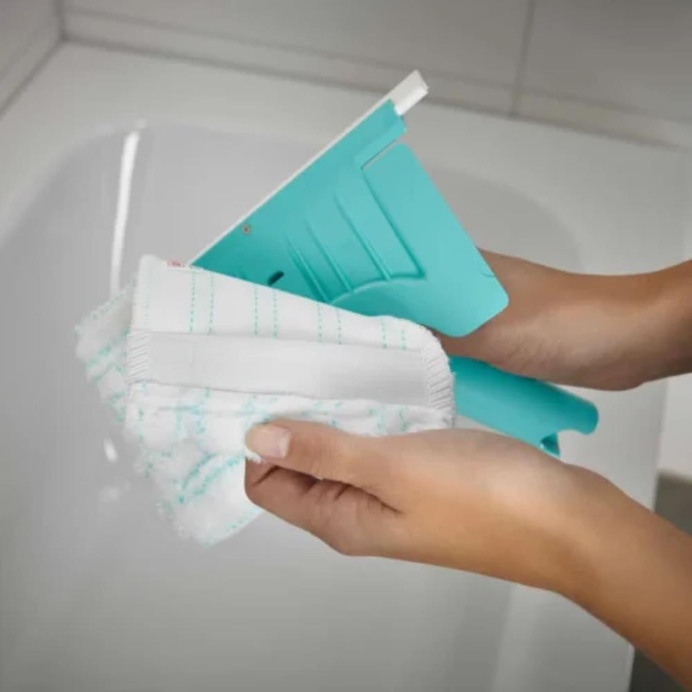 Person holding a teal cleaning tool with white cloths inside a sink.