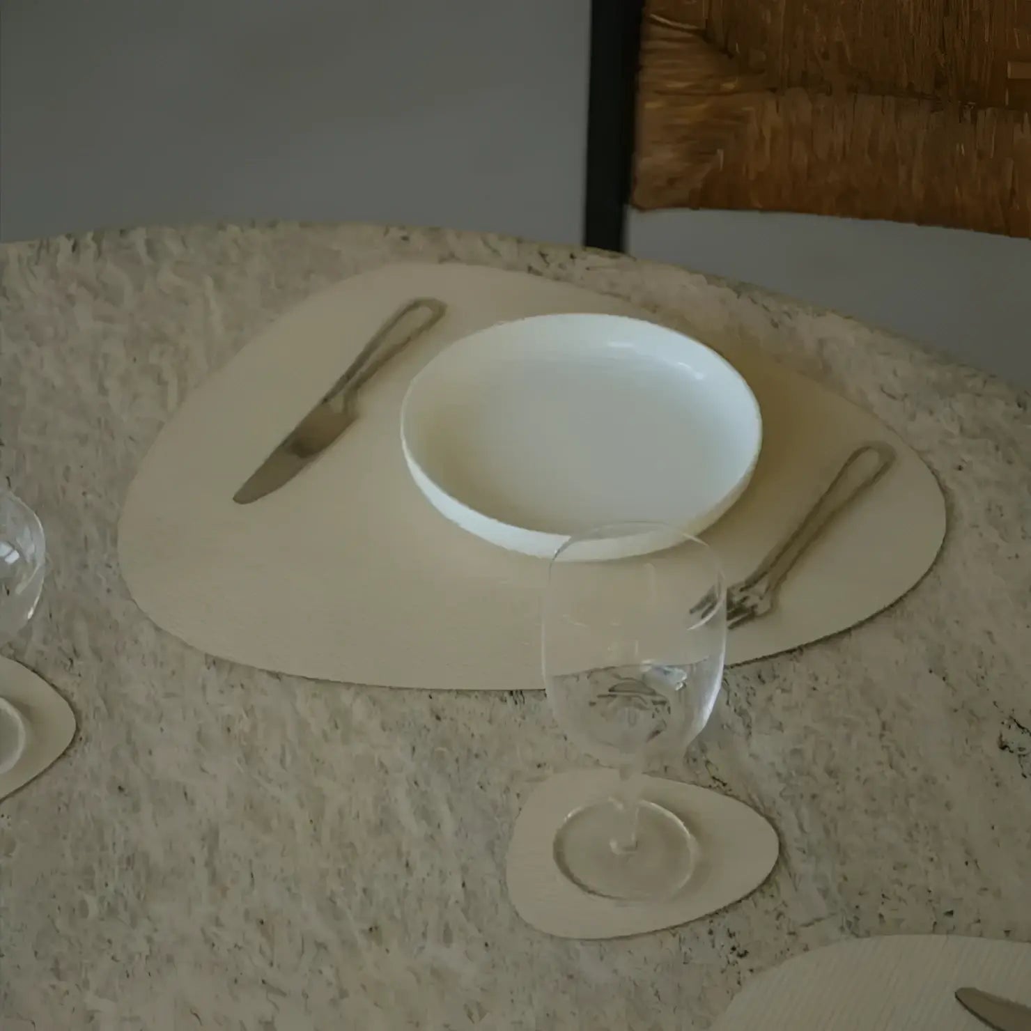 Dining table setting with heart-shaped placemats, plates, and cutlery on a textured surface.