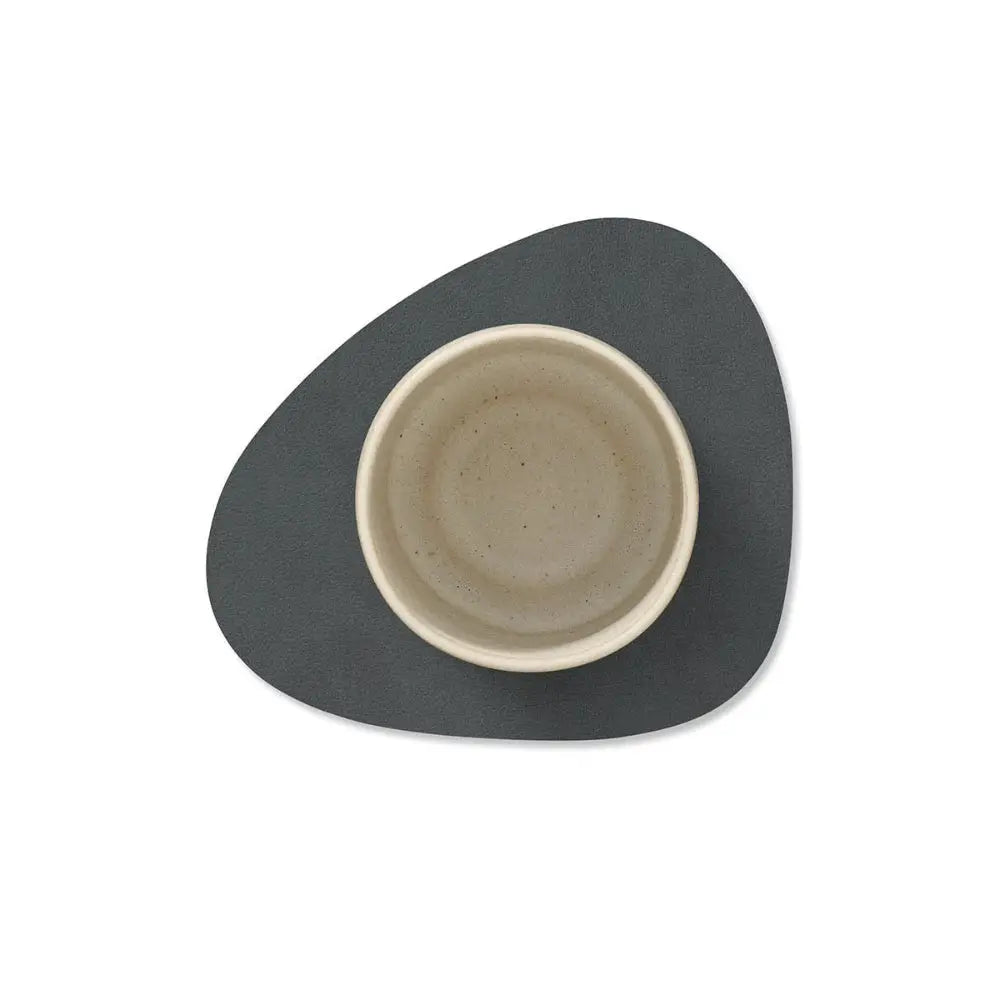 leather coaster with a beige mug on a white background