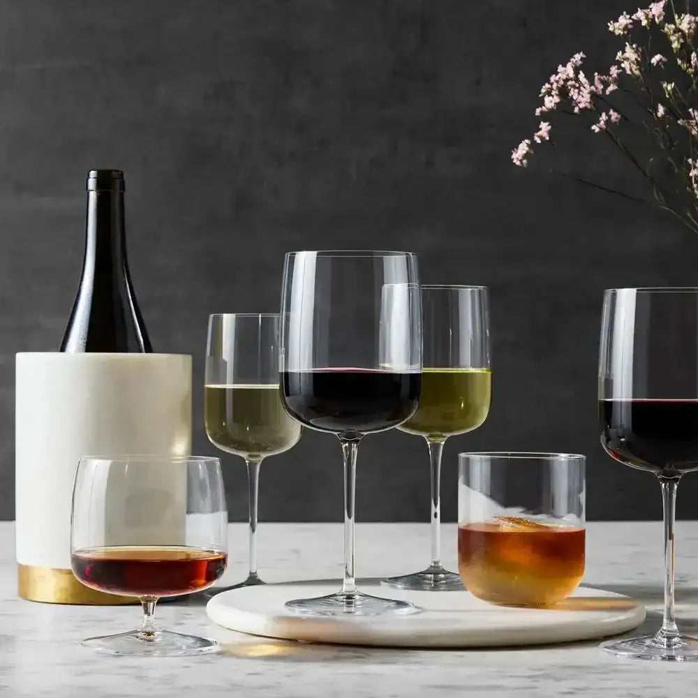 Wine bottle and glasses with different types of wine on a dark background