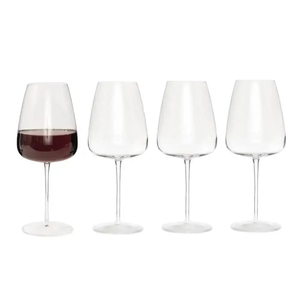 Set of four wine glasses with one containing red wine on a white background
