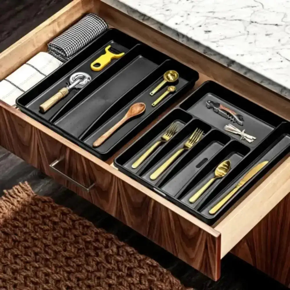 Black madesmart classic antimicrobial large cutlery tray in carbon with segmented compartments holding gold kitchen tools