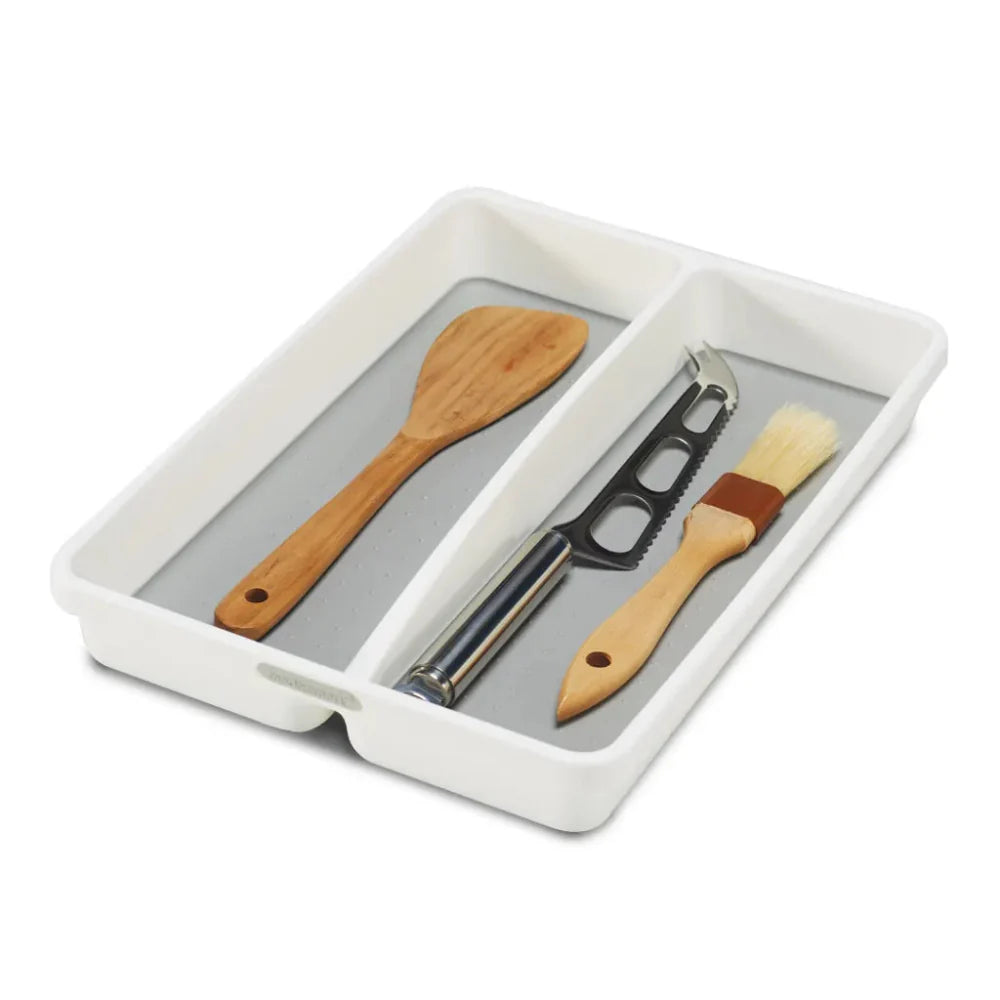 Set of kitchen utensils including a wooden spatula and basting brush in a white tray on a white background
