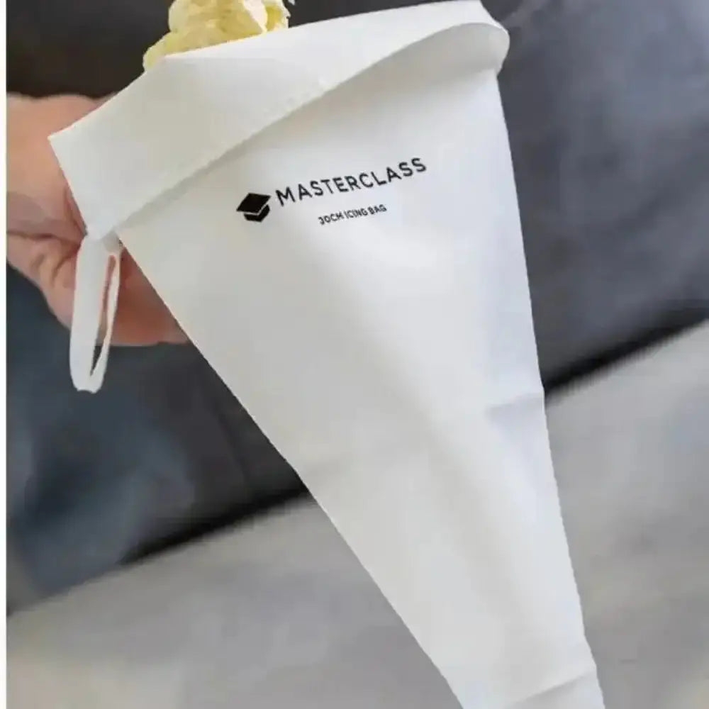 White piping bag with 'Masterclass' branding held by a person.