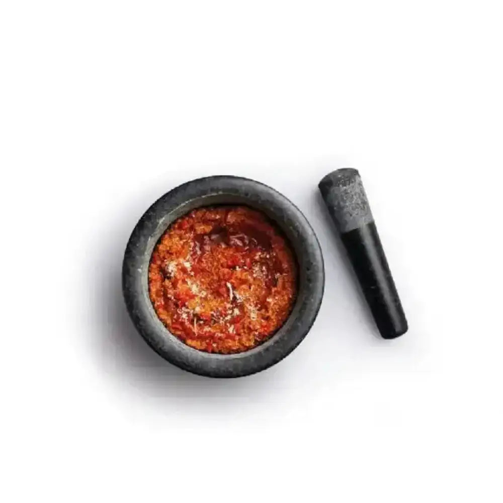 Mortar and pestle with red spice on a white background