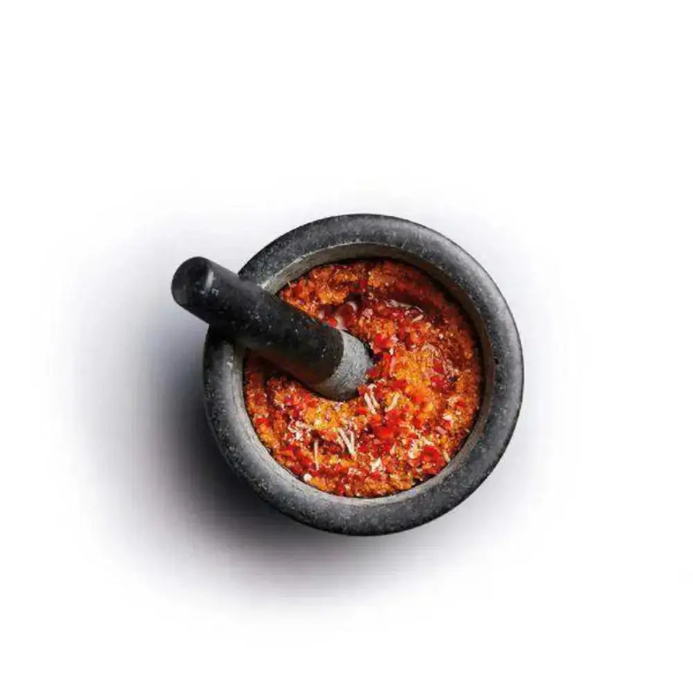 Mortar and pestle with ground spices on a white background