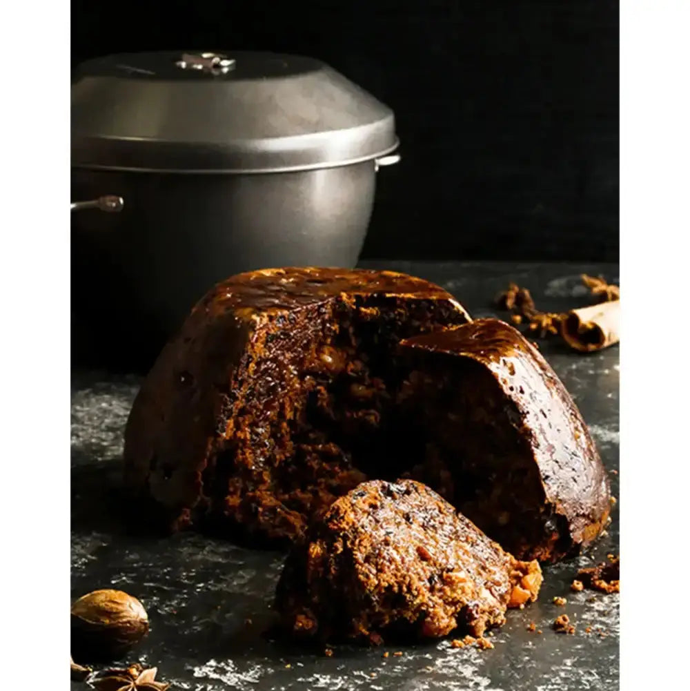 Dark brown baked pudding with a metal container in the background