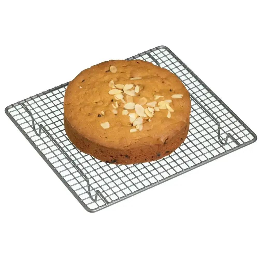Round cake with almonds on a wire cooling rack against a white background