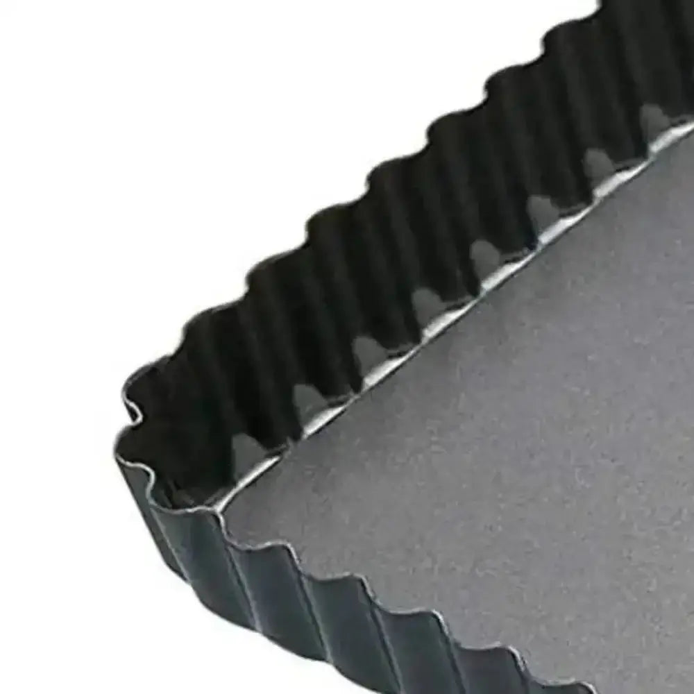 Gray tart pan with a ribbed edge on a white background