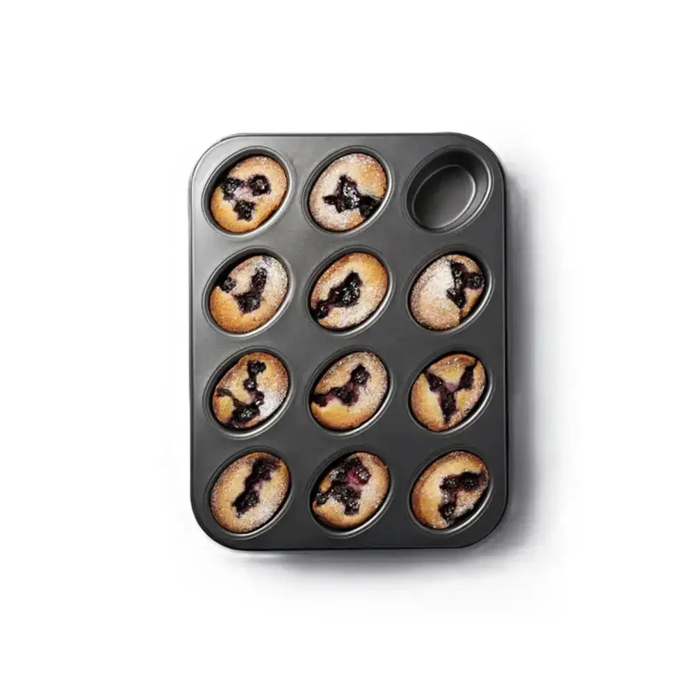 Muffin tin with baked muffins on a white background