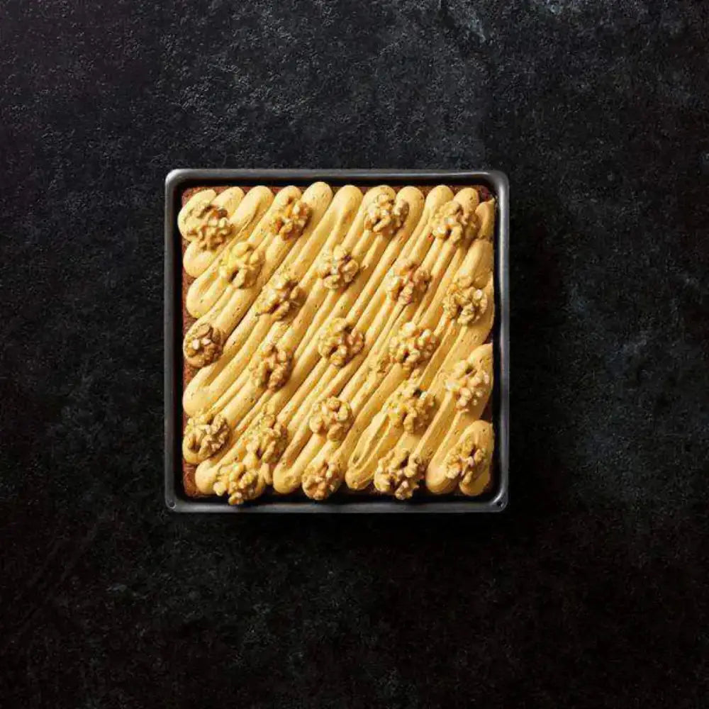 Baked good in a square pan on a dark background