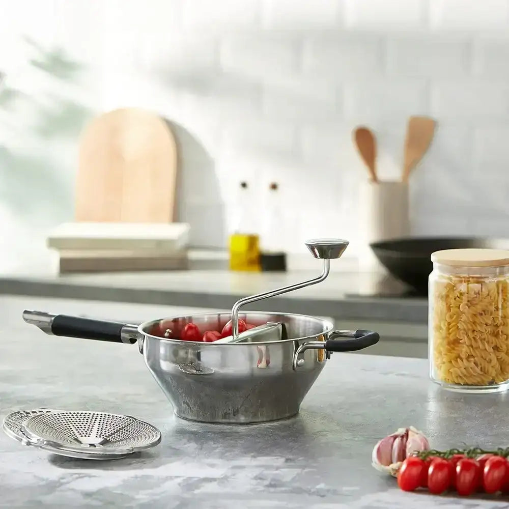 Stainless steel colander with tomatoes on a kitchen counter