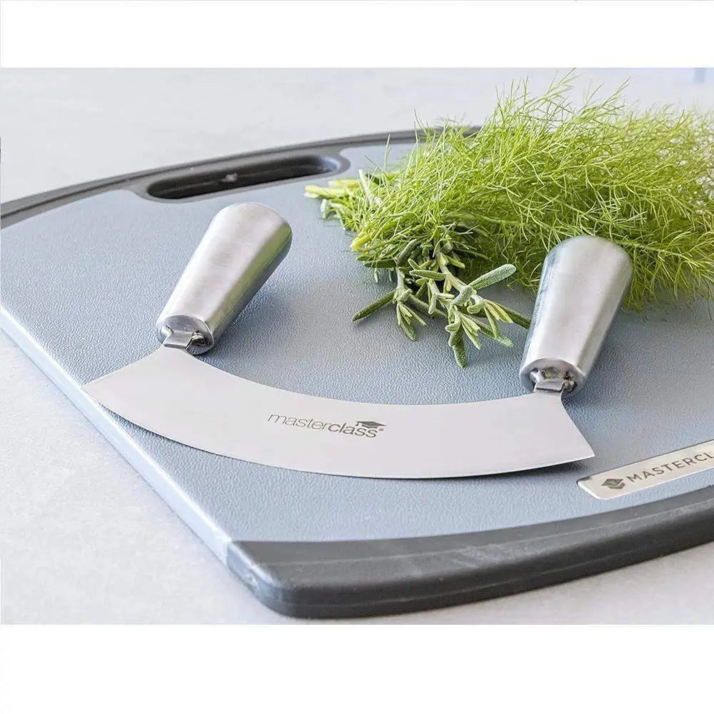 Masterclass curved knife on a cutting board with green herbs