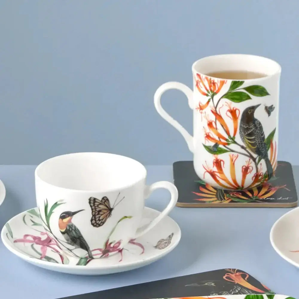Cup and saucer with nature-themed design on a blue background