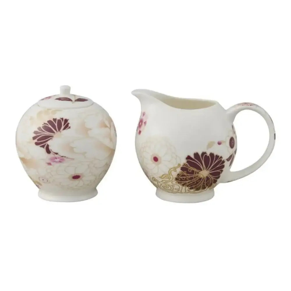 Tea pot and creamer set with floral design on a white background