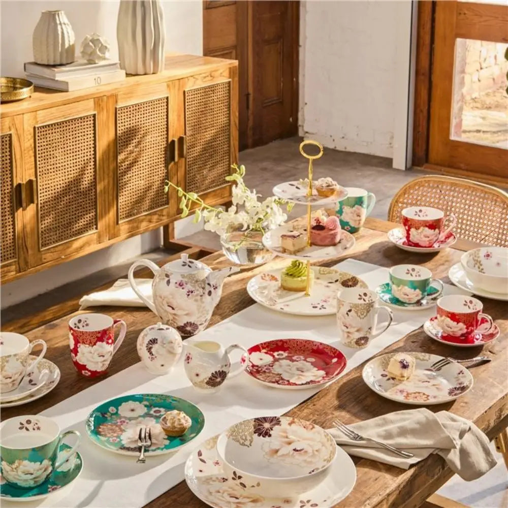 Tea set on a wooden table with floral patterns in a cozy room.
