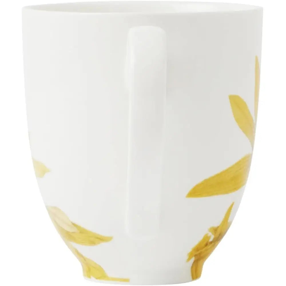 White mug with yellow leaf patterns on a white background