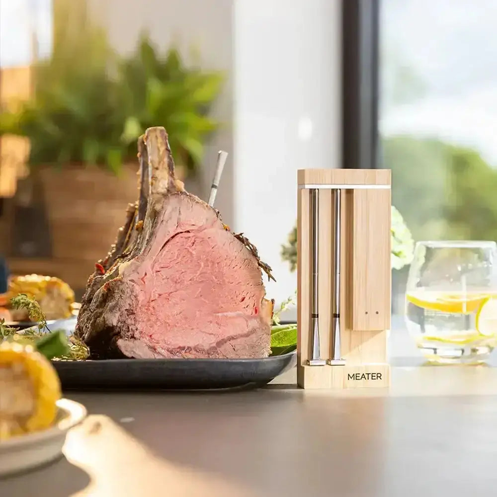 Meater digital meat thermometer next to a cooked roast on a dining table