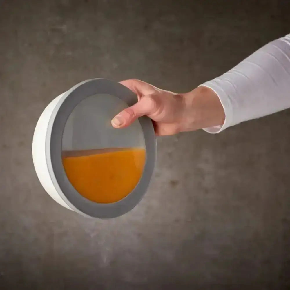 White and gray circular mepal cirqula deep bowl with transparent lid holding orange liquid in set of 3